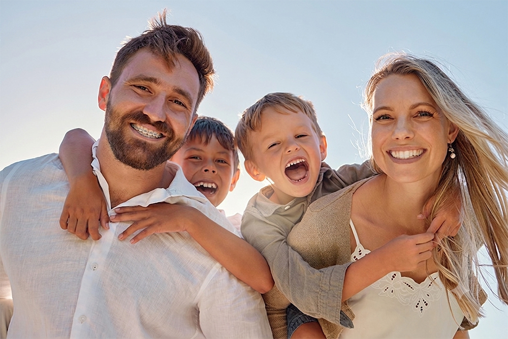 parents and kids standing in front of a sunset